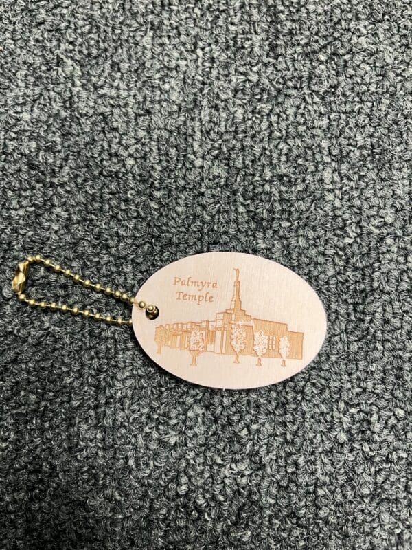 A wooden keychain with an image of the temple.