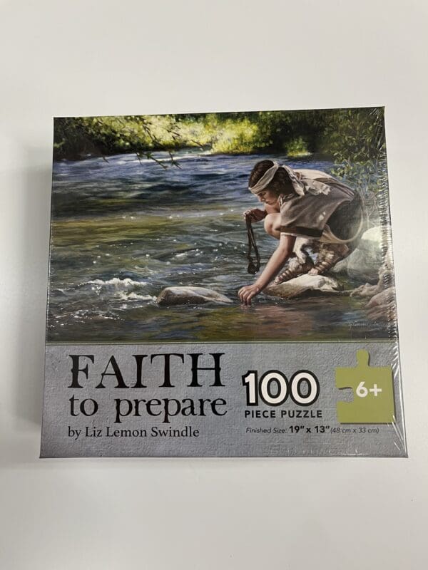 A box of puzzle with a man kneeling in water.