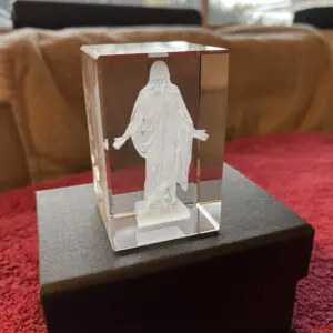 A glass cube with jesus on it sitting in front of a couch.