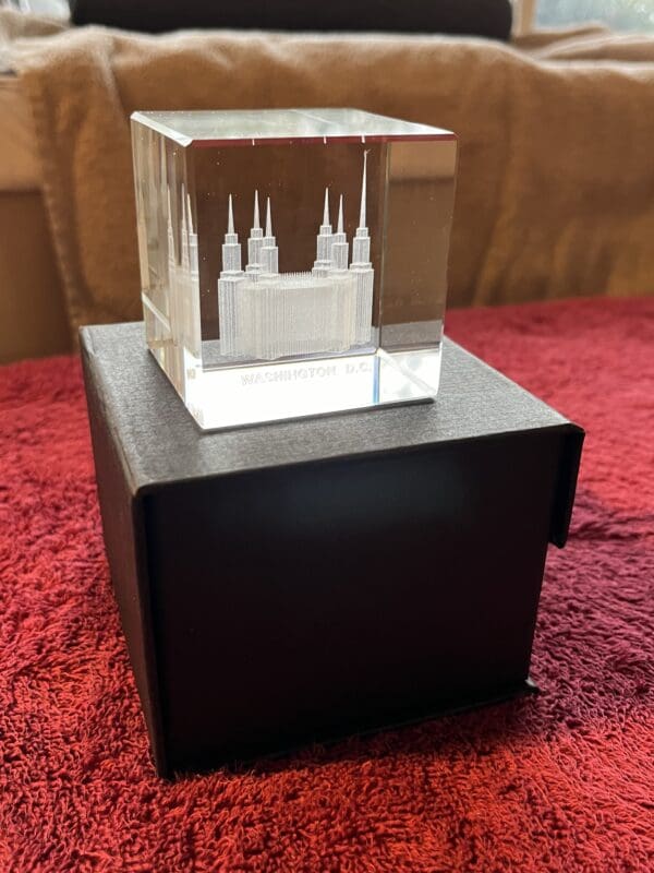 A small glass cube with a castle on it