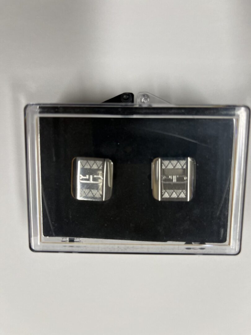 A pair of square shaped buttons hanging on the wall.