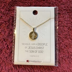 A necklace that says " behold i am a disciple of jesus christ the son of god ".