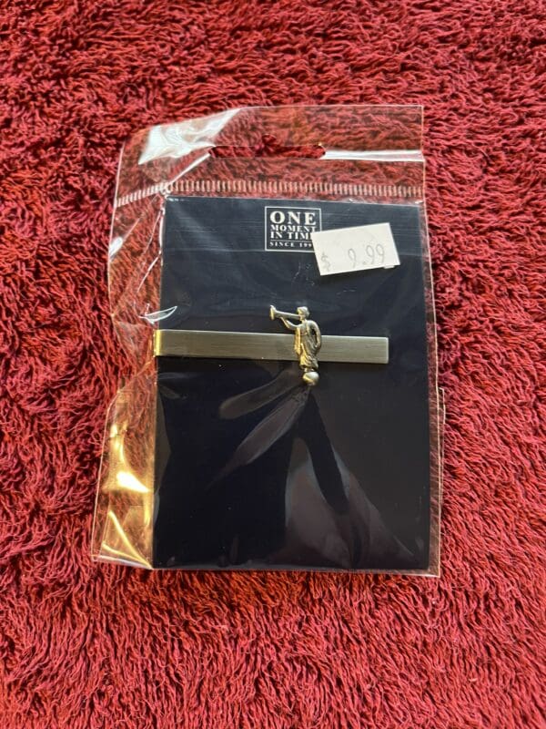 A black bag with a gold bar and feather on it