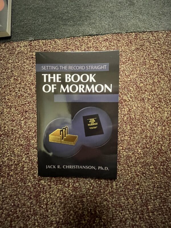 A book of mormon sitting on the floor.