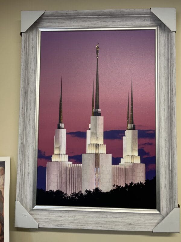 A window with the image of three towers in front of a purple sky.