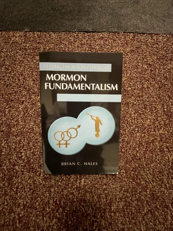 A book on mormon fundamentalism is laying on the floor.