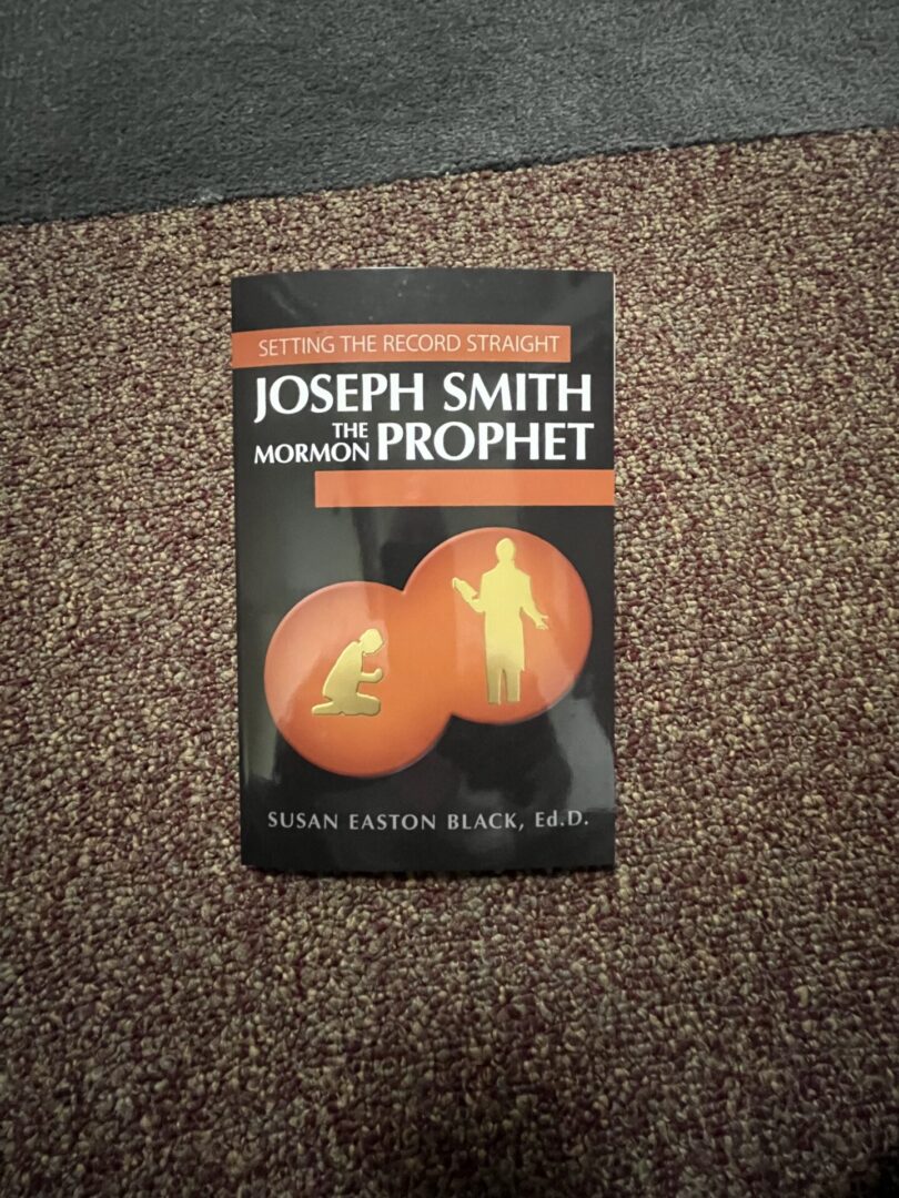 A book sitting on the ground with an orange in it.