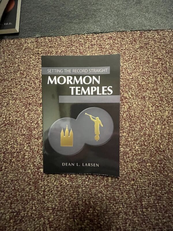 A book about mormon temples is laying on the floor.